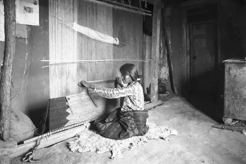 A Navajo woman weaves handmade American Indian blankets