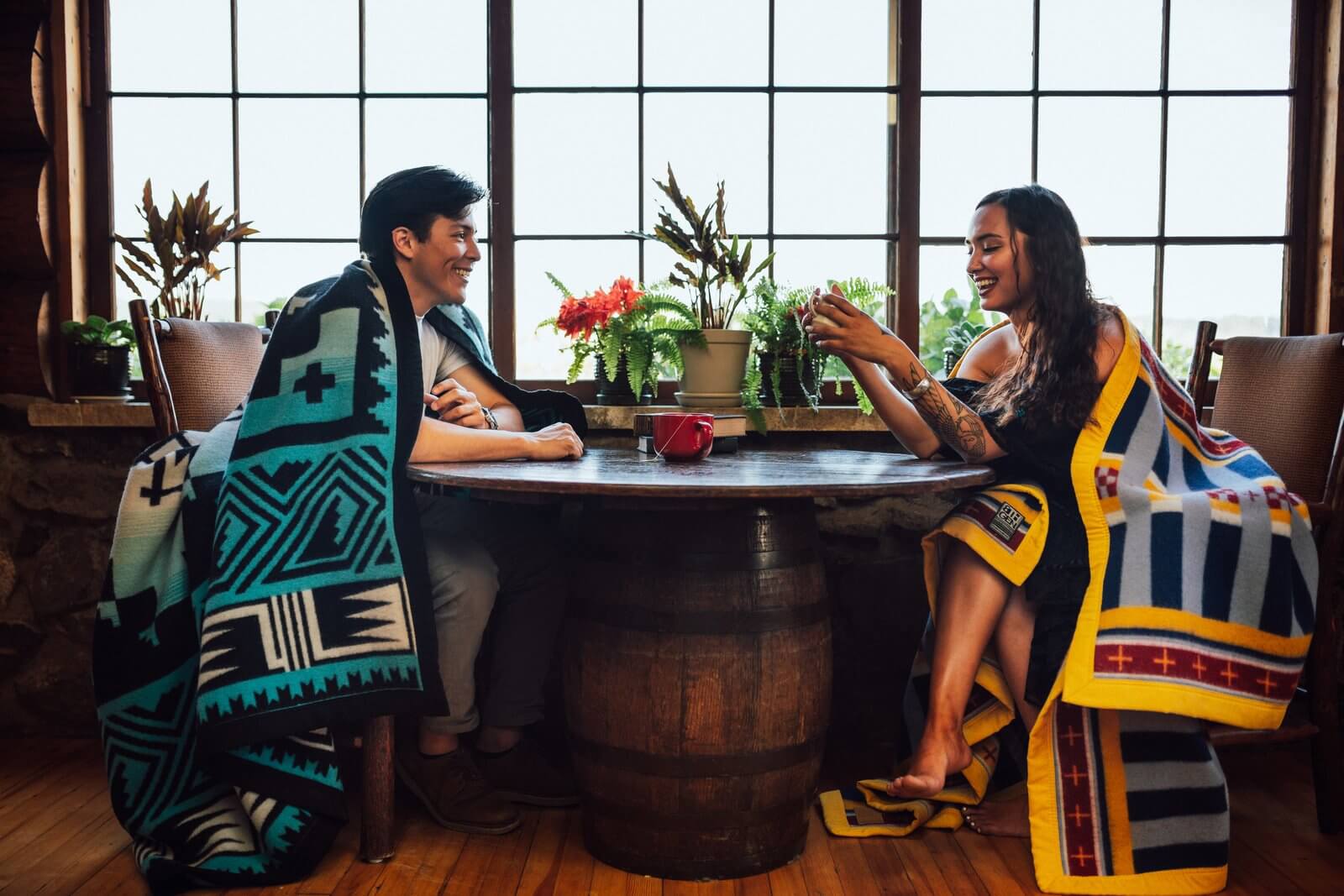 A couple wearing American Indian blankets indoor