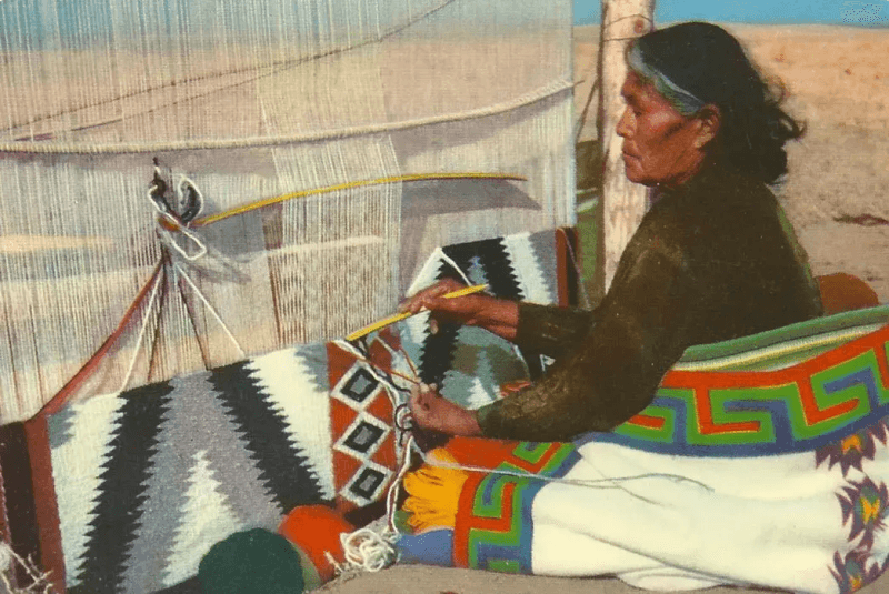 A woman makees Navajo American Indian blankets 