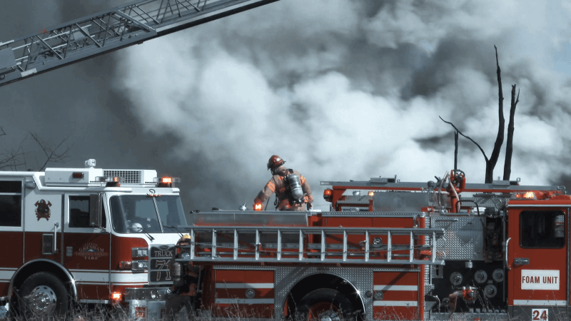 firefighters working together bringing supplies to fire